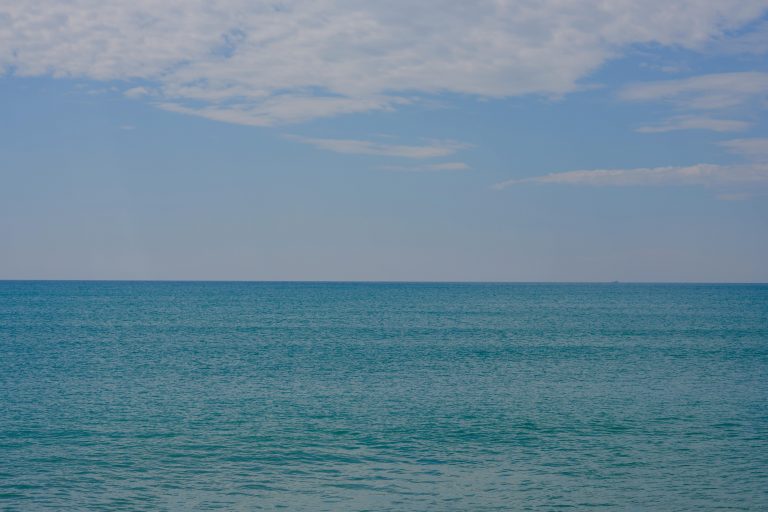 A serene and calming ocean horizon under a bright blue sky, perfect for relaxation.